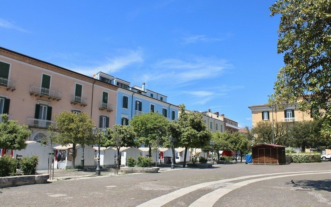 Kleiner Marktplatz mit Bäumen, Sitzbereichen und historischen Häusern